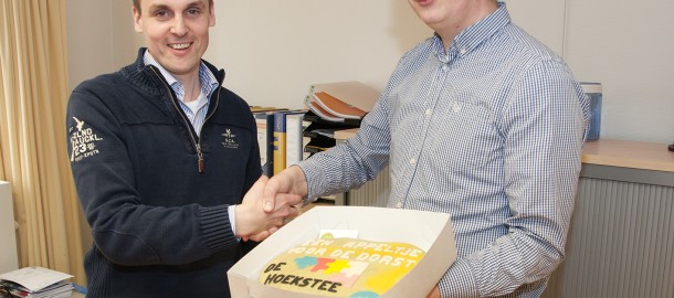 Richard Veurink (CU Ommen) overhandigt aan de directeur Henk Martens een "appeltaart".